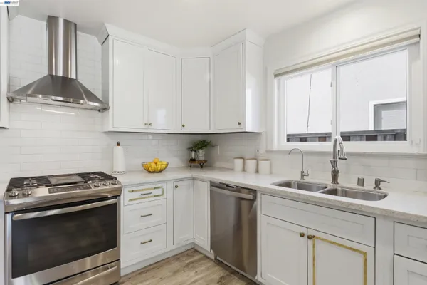a kitchen with stainless steel appliances a stove a sink and cabinets