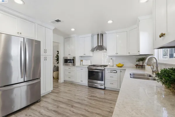 a kitchen with stainless steel appliances a refrigerator sink and stove