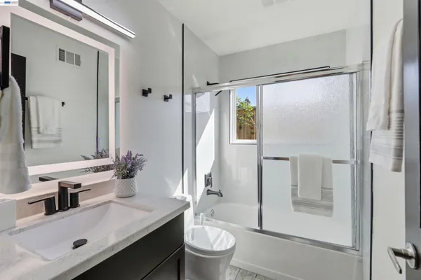 a bathroom with a glass shower door and a sink