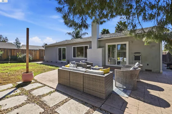 a view of a backyard with table and chairs and a large tree