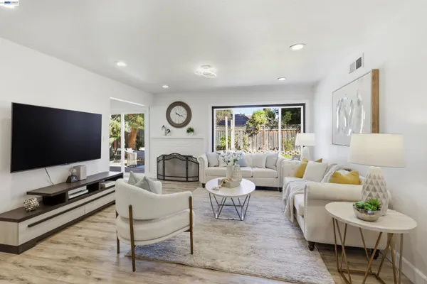 a living room with furniture flat screen tv and a large window