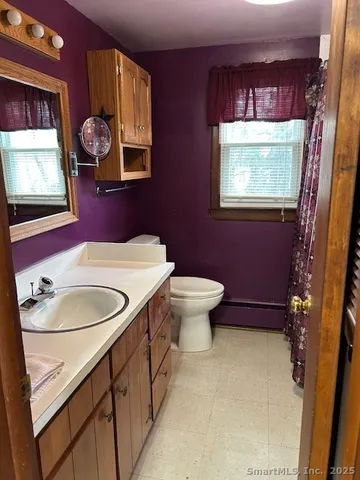 a bathroom with a toilet sink and mirror