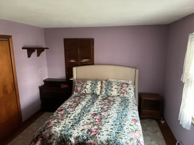 a bed sitting in a bedroom next to a window