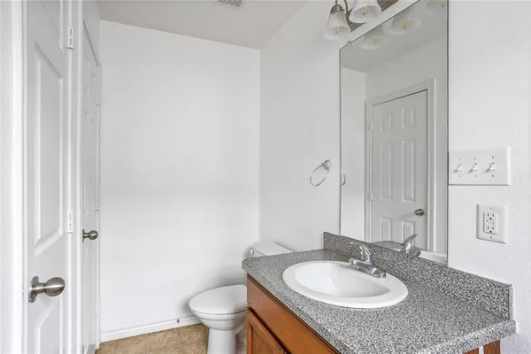 a bathroom with a granite countertop sink toilet and a mirror