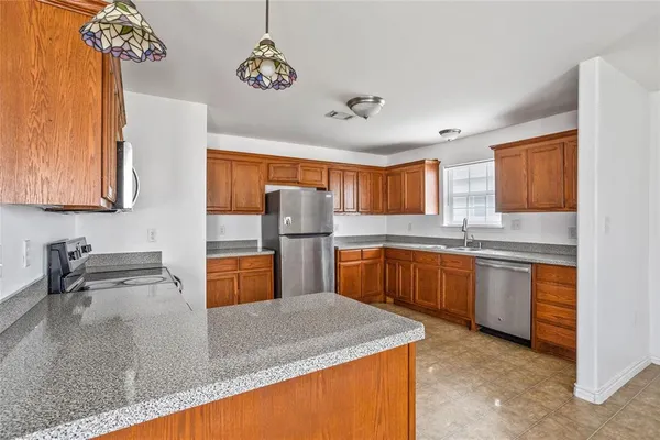 a kitchen with stainless steel appliances granite countertop sink stove and refrigerator