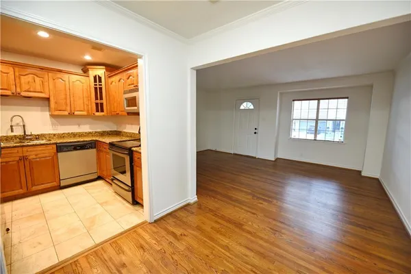 a kitchen with granite countertop a stove a sink and a refrigerator