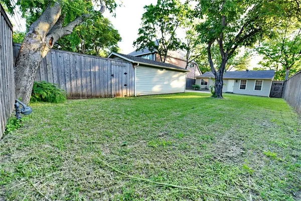 a view of a backyard with table and chairs and a large tree