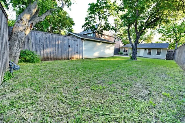 a view of a backyard with table and chairs and a large tree