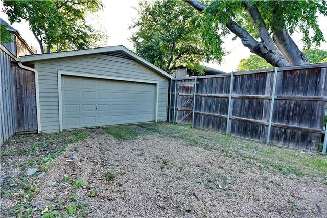 a backyard of a house with a small barn and wooden fence