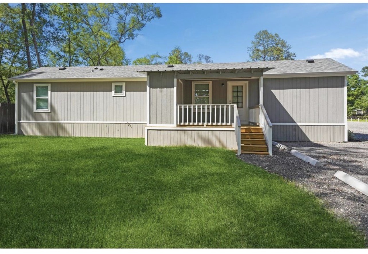 a view of a house with a yard and sitting area