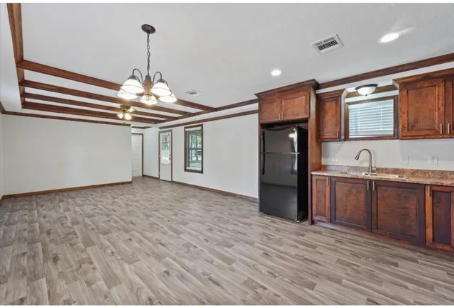 a view of a kitchen with a sink and refrigerator