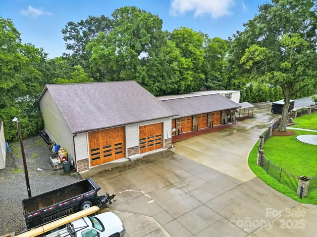 an aerial view of a house with swimming pool and a yard