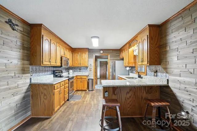 a kitchen with granite countertop a sink stove and cabinets