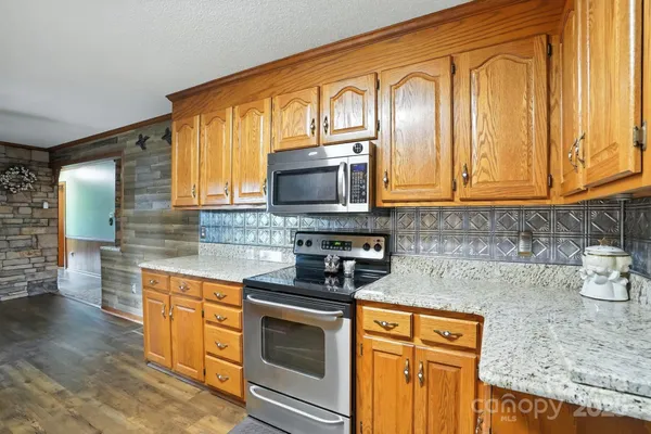 a kitchen with stainless steel appliances granite countertop a stove a sink and a microwave