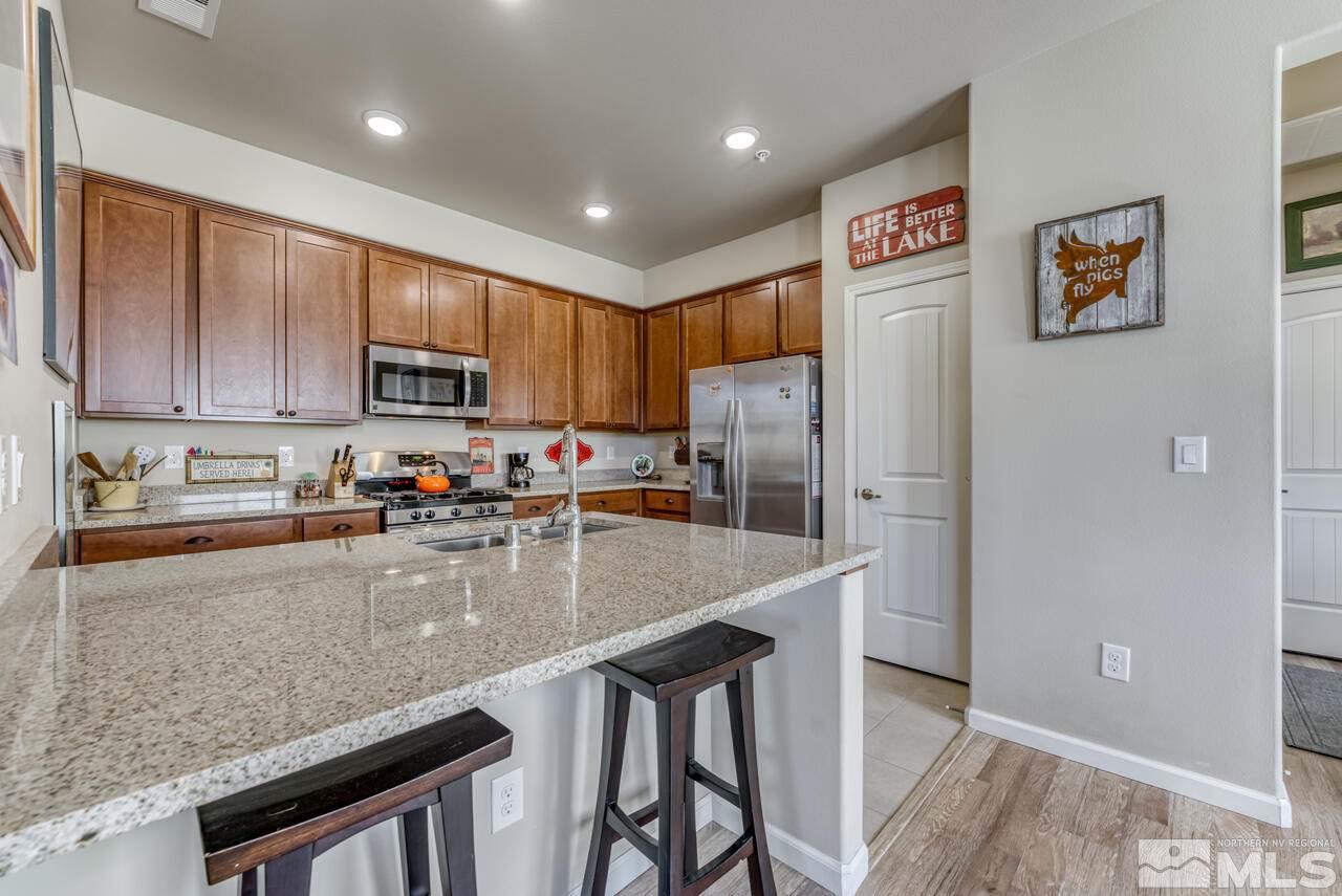 2490 Eastshore Place, Unit 208 Reno, NV 89509 - Photo 13 of 36 a kitchen with granite countertop a refrigerator and a stove top oven