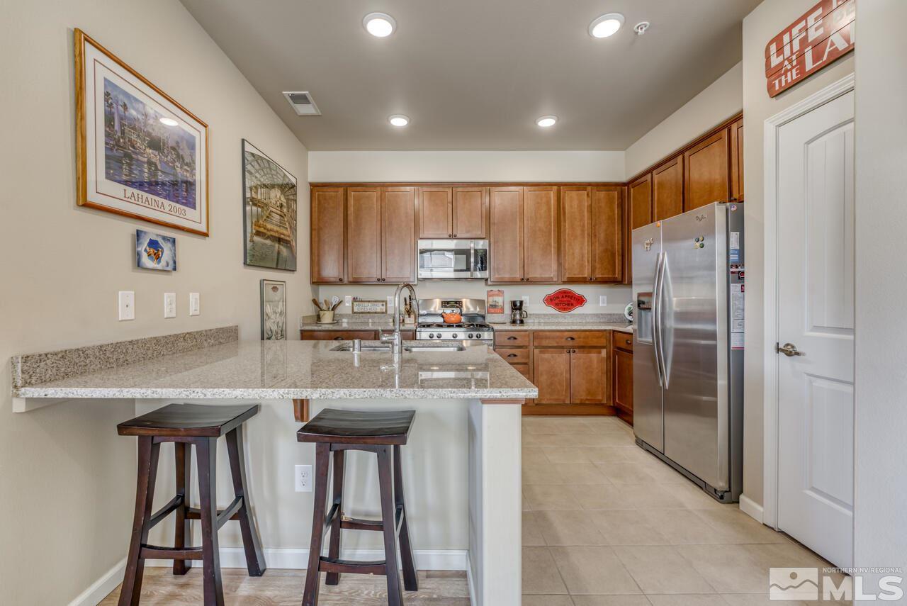 2490 Eastshore Place, Unit 208 Reno, NV 89509 - Photo 14 of 36 a kitchen with refrigerator cabinets and chairs