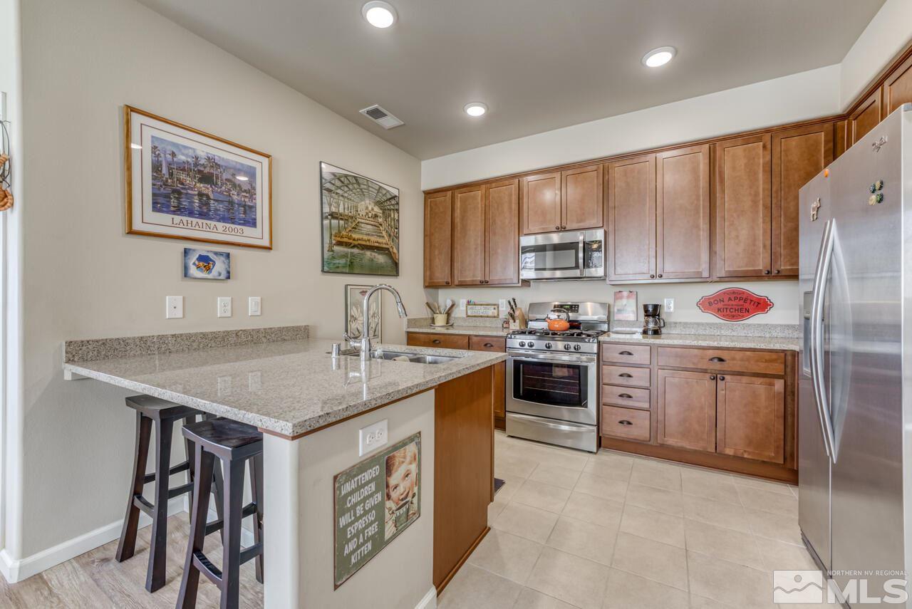 2490 Eastshore Place, Unit 208 Reno, NV 89509 - Photo 15 of 36 a kitchen with stainless steel appliances granite countertop a stove refrigerator sink and cabinets