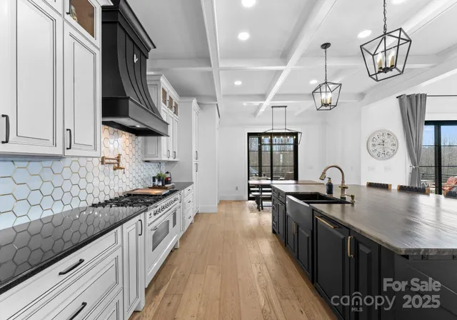 a kitchen with granite countertop a sink a stove and cabinets