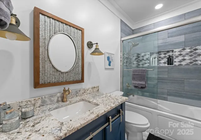 a bathroom with a granite countertop sink mirror vanity and toilet