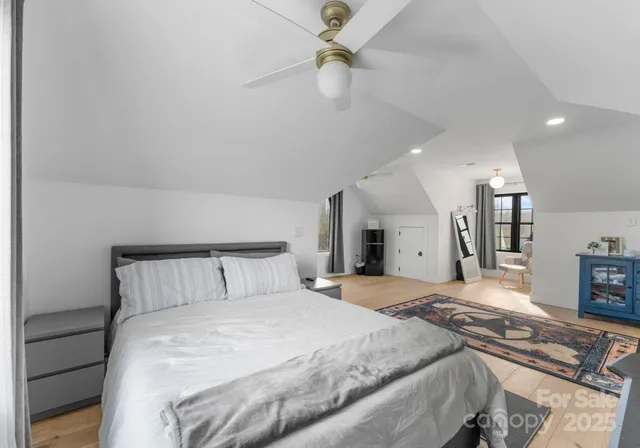 a bedroom with a large bed and a chandelier