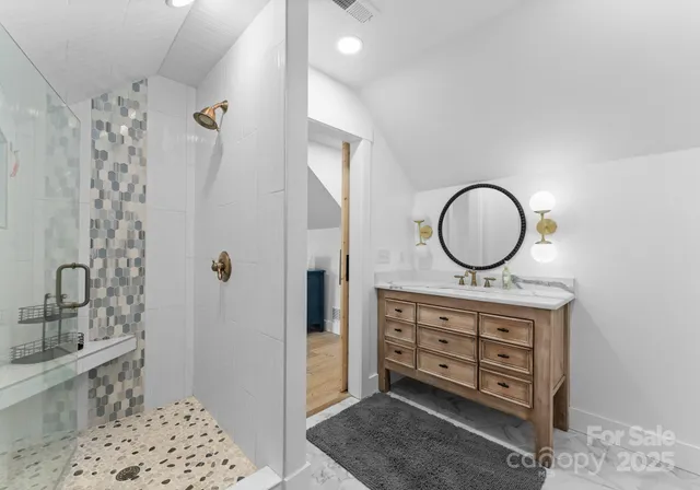 a view of a bathroom with a sink mirror and shower