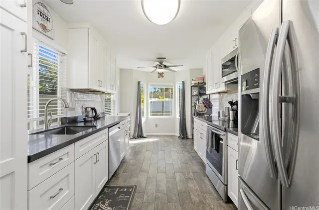 a kitchen with stainless steel appliances a sink stove and refrigerator