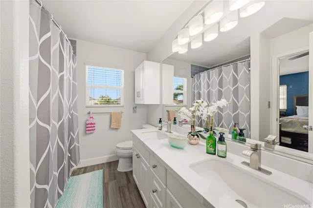 a bathroom with a sink a toilet and a shower curtain