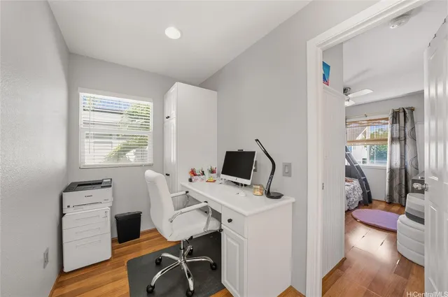 a view of a workspace with furniture and a window