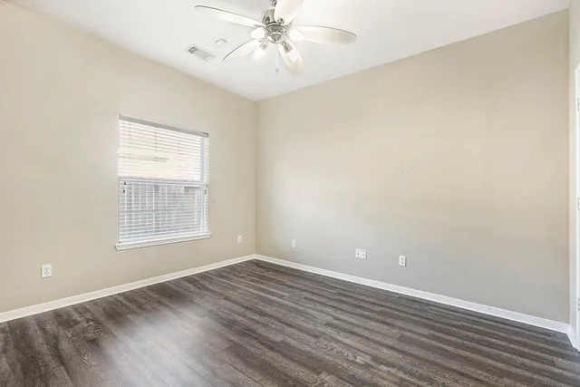 wooden floor in an empty room with a window