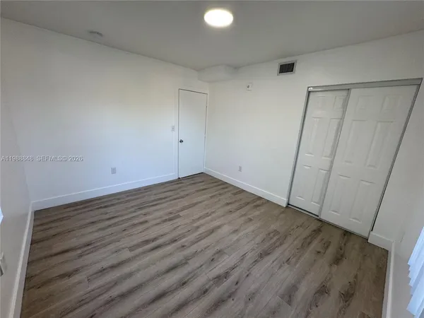 a view of an empty room with wooden floor