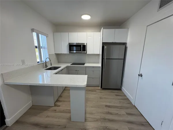a kitchen with kitchen island a sink appliances and cabinets
