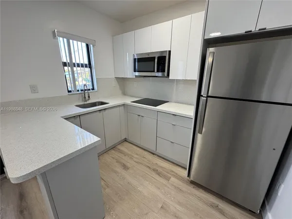 a kitchen with a refrigerator sink and microwave