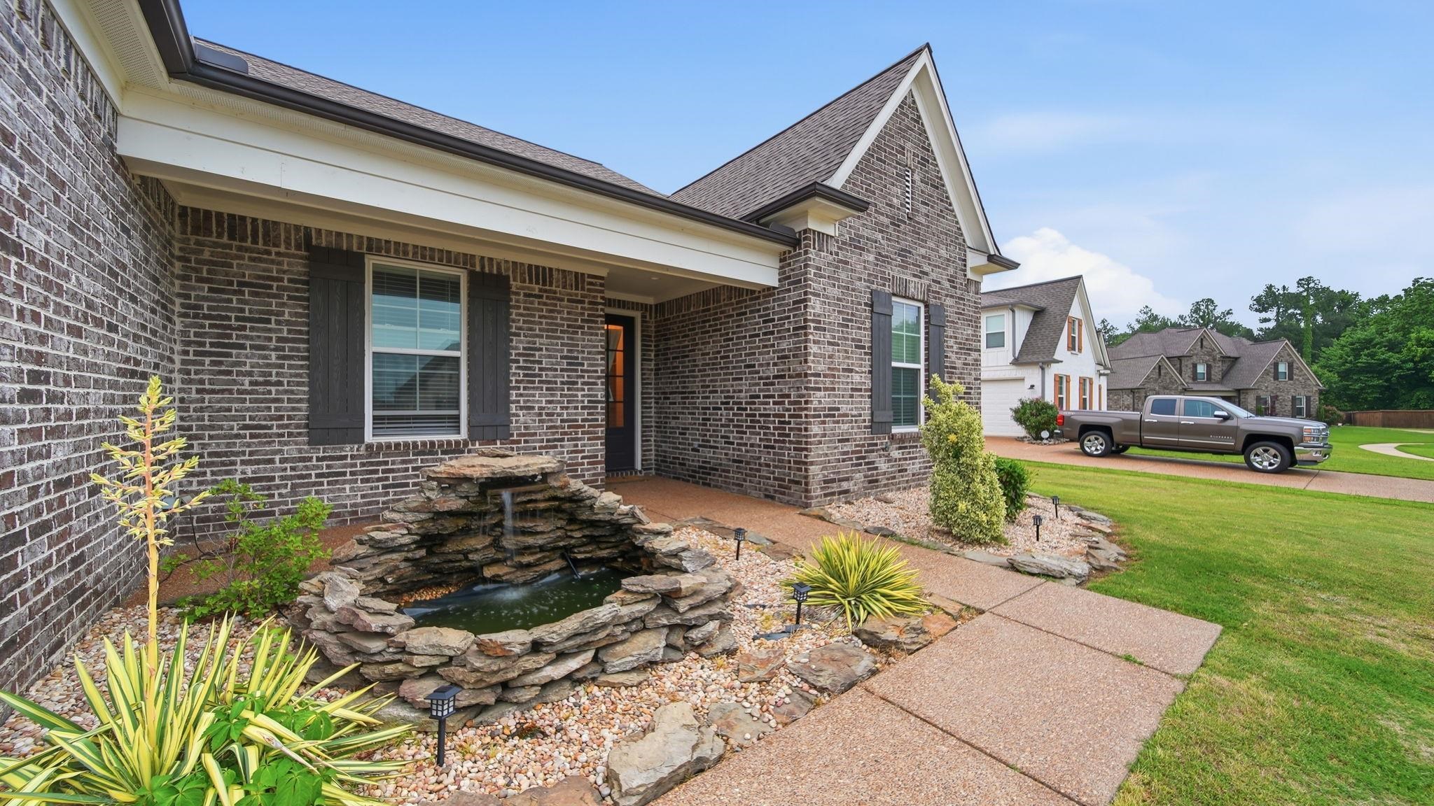 70 Trinity Cove Atoka, TN 38004 - Photo 3 of 25 Brick exterior featuring a gabled roofline and dark window shutters