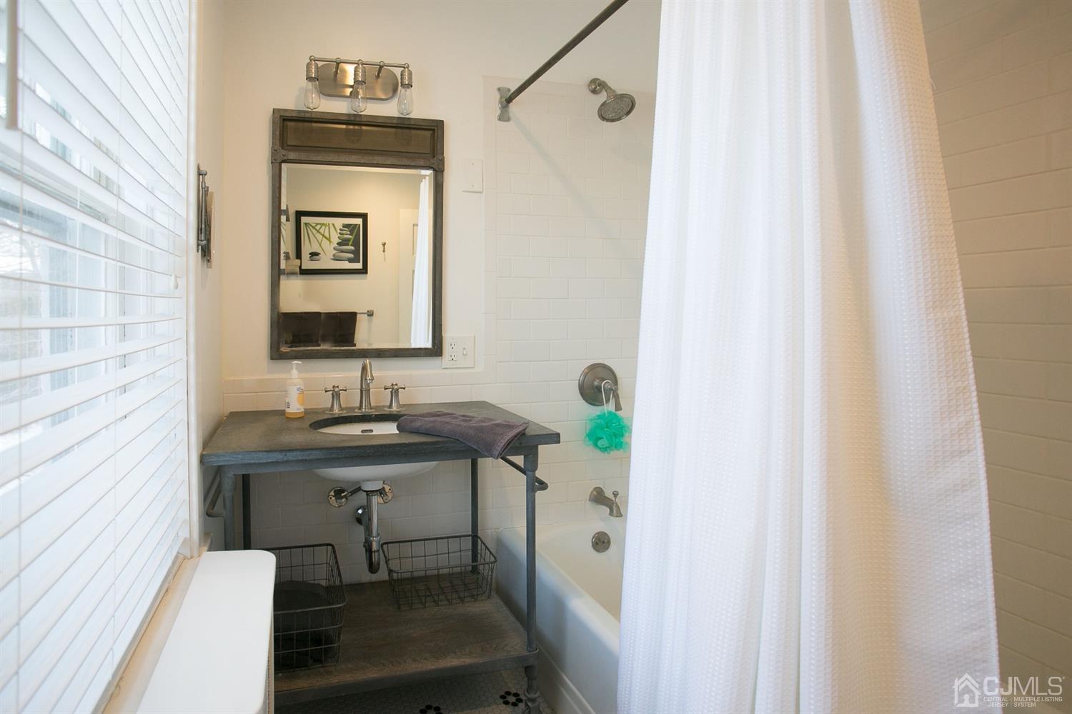 68 Rector Street Metuchen, NJ 08840 - Photo 27 of 40 a bathroom with a sink a mirror and a shower curtain