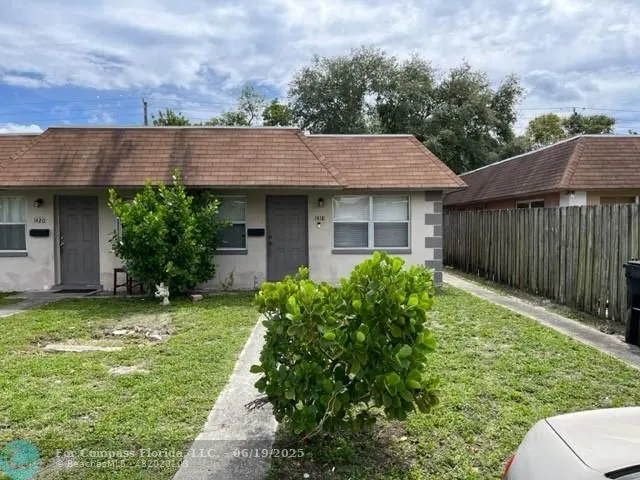 a backyard of a house with plants and large tree