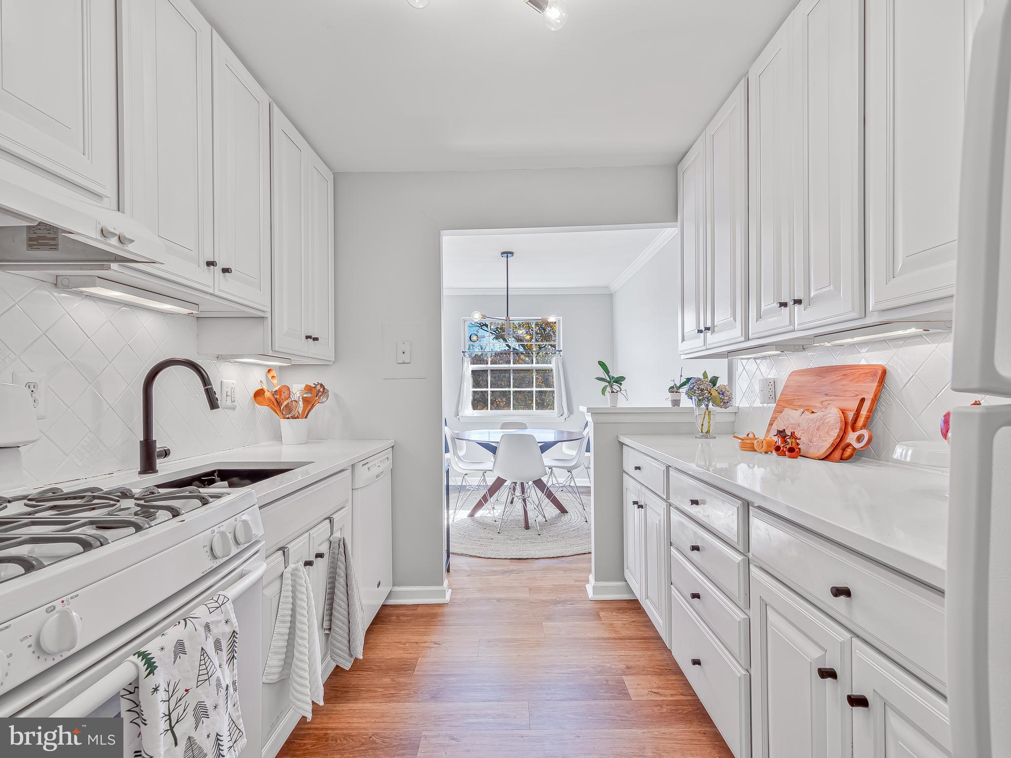1914 Wilson Lane, Unit 202 McLean, VA 22102 - Photo 18 of 42 a kitchen with granite countertop a stove top oven a sink dishwasher and cabinets with wooden floor