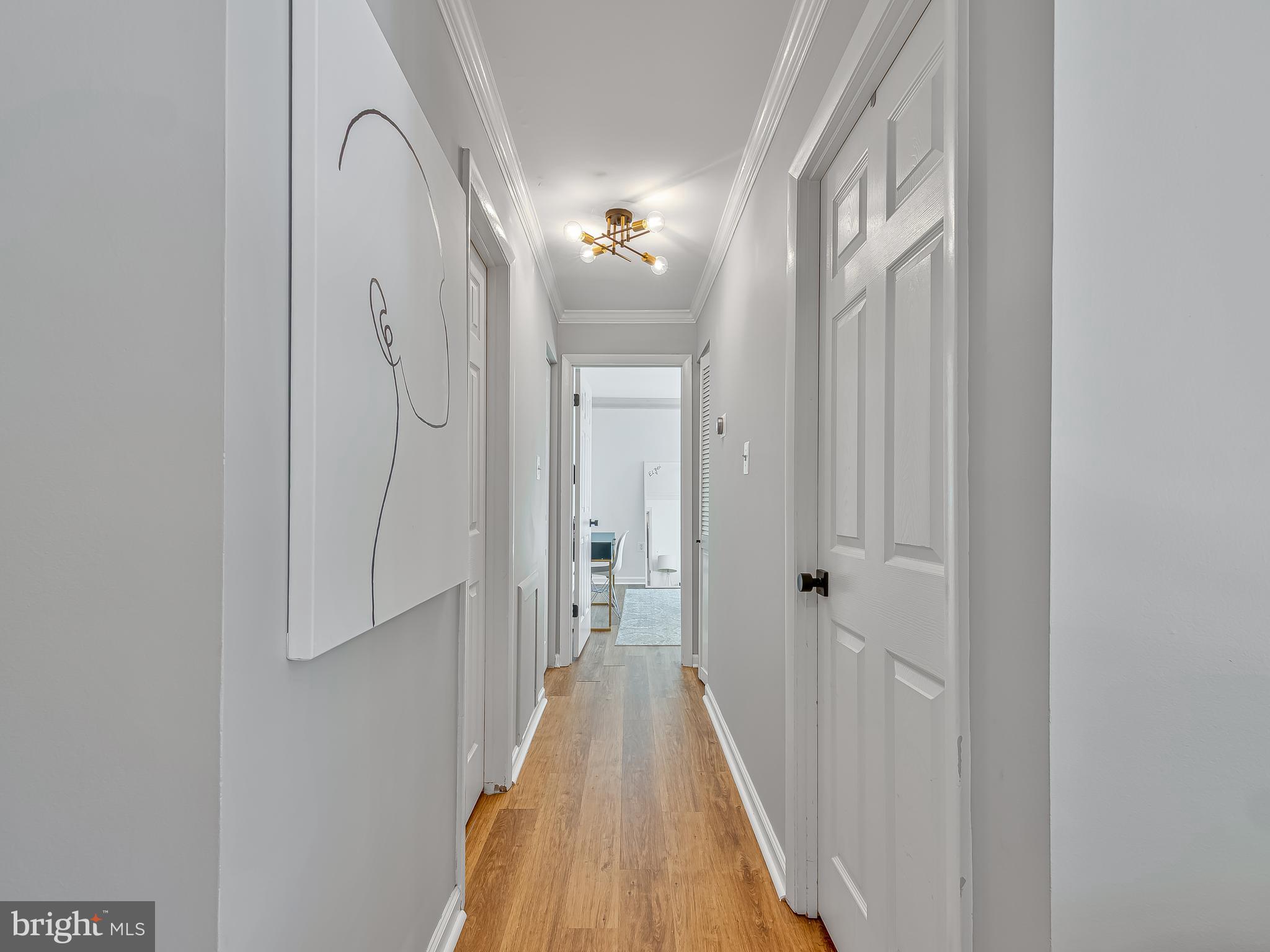 1914 Wilson Lane, Unit 202 McLean, VA 22102 - Photo 20 of 42 a view of a hallway with wooden floor and a chandelier