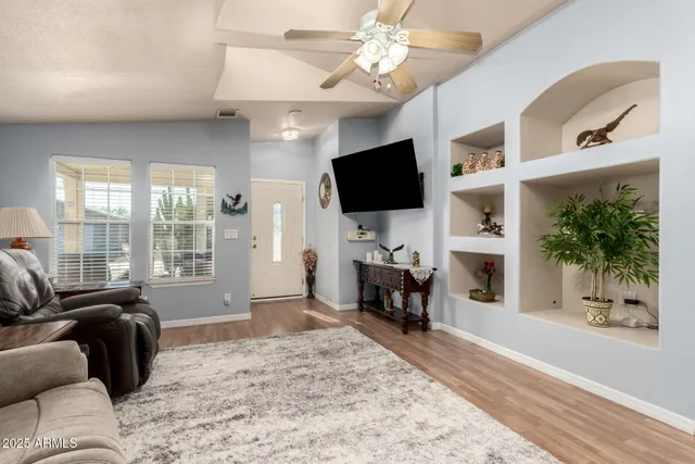 a living room with furniture a flat screen tv and a fireplace