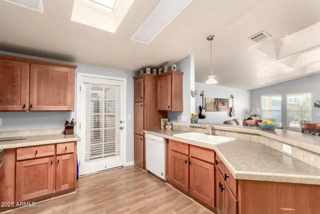 a kitchen with a sink a stove cabinets and wooden floor