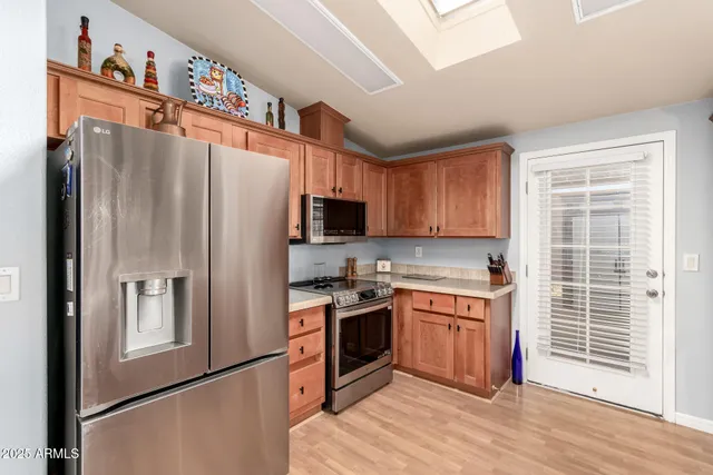 a kitchen with stainless steel appliances granite countertop a refrigerator stove and sink