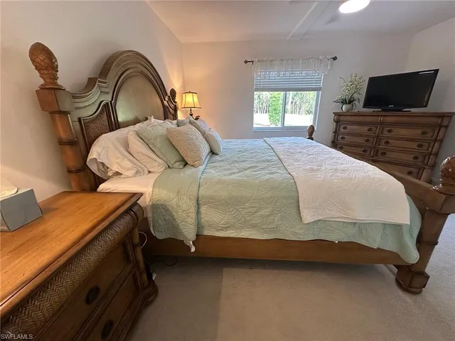 a bedroom with a bed and a television