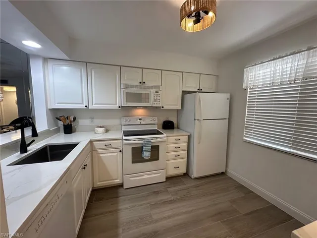 a kitchen with a white cabinets and white appliances