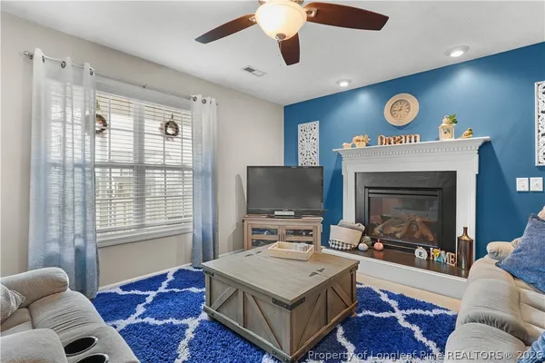 a living room with furniture a fireplace and a flat screen tv
