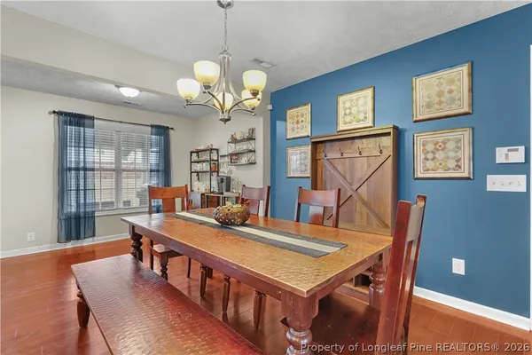 a view of a dining room with furniture and a chandelier