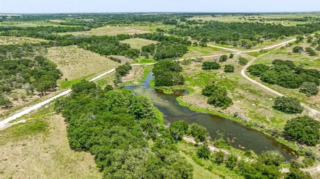 an aerial view of residential houses with outdoor space and trees