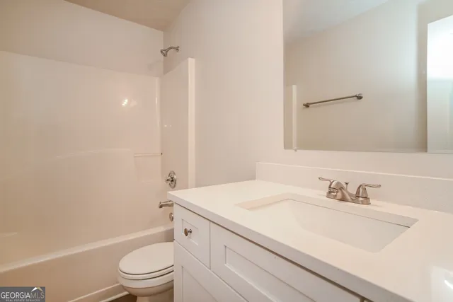 a bathroom with a sink toilet vanity and shower