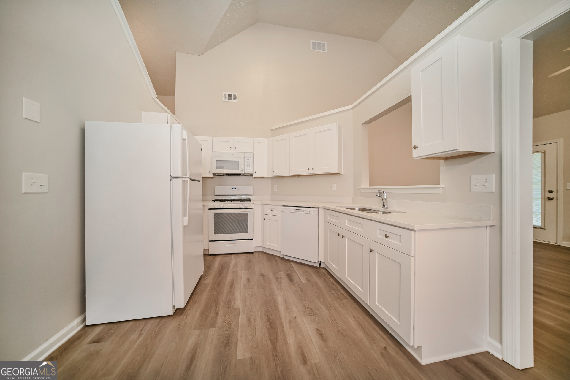 60 Freeman Way Covington, GA 30016 - Photo 5 of 17 a kitchen with cabinets wooden floor and stainless steel appliances
