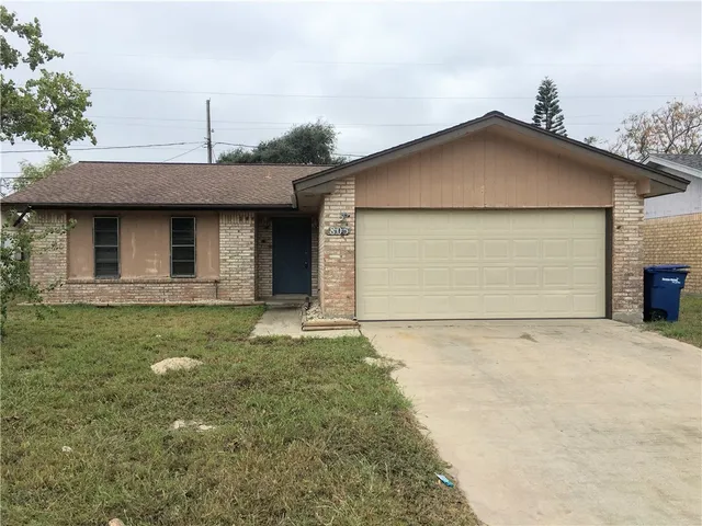 a front view of a house with a garden and yard