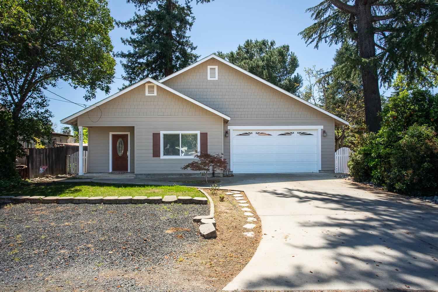 a front view of a house with a yard and trees