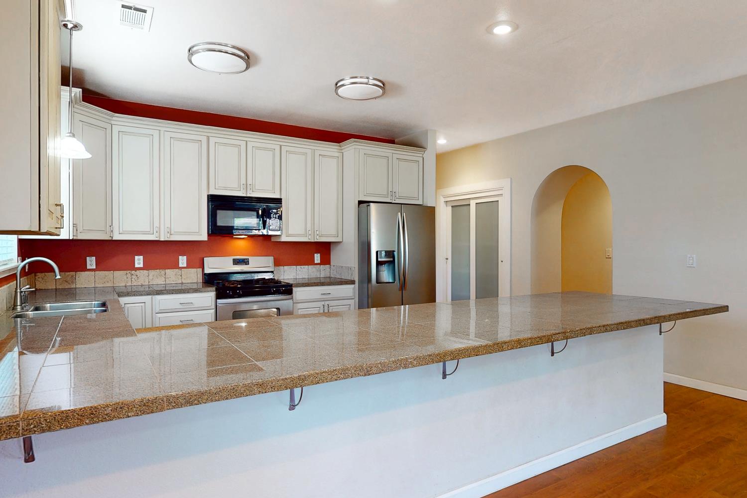 1835 Magnolia Street Gridley, CA 95948 - Photo 6 of 53 a kitchen with stainless steel appliances granite countertop a refrigerator a stove and a sink with wooden floor